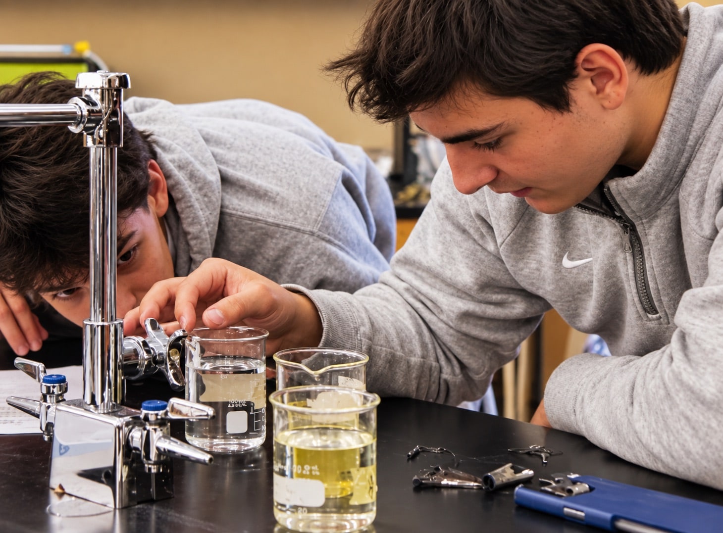 Two students concentrating on a science experiment with beakers at a laboratory bench