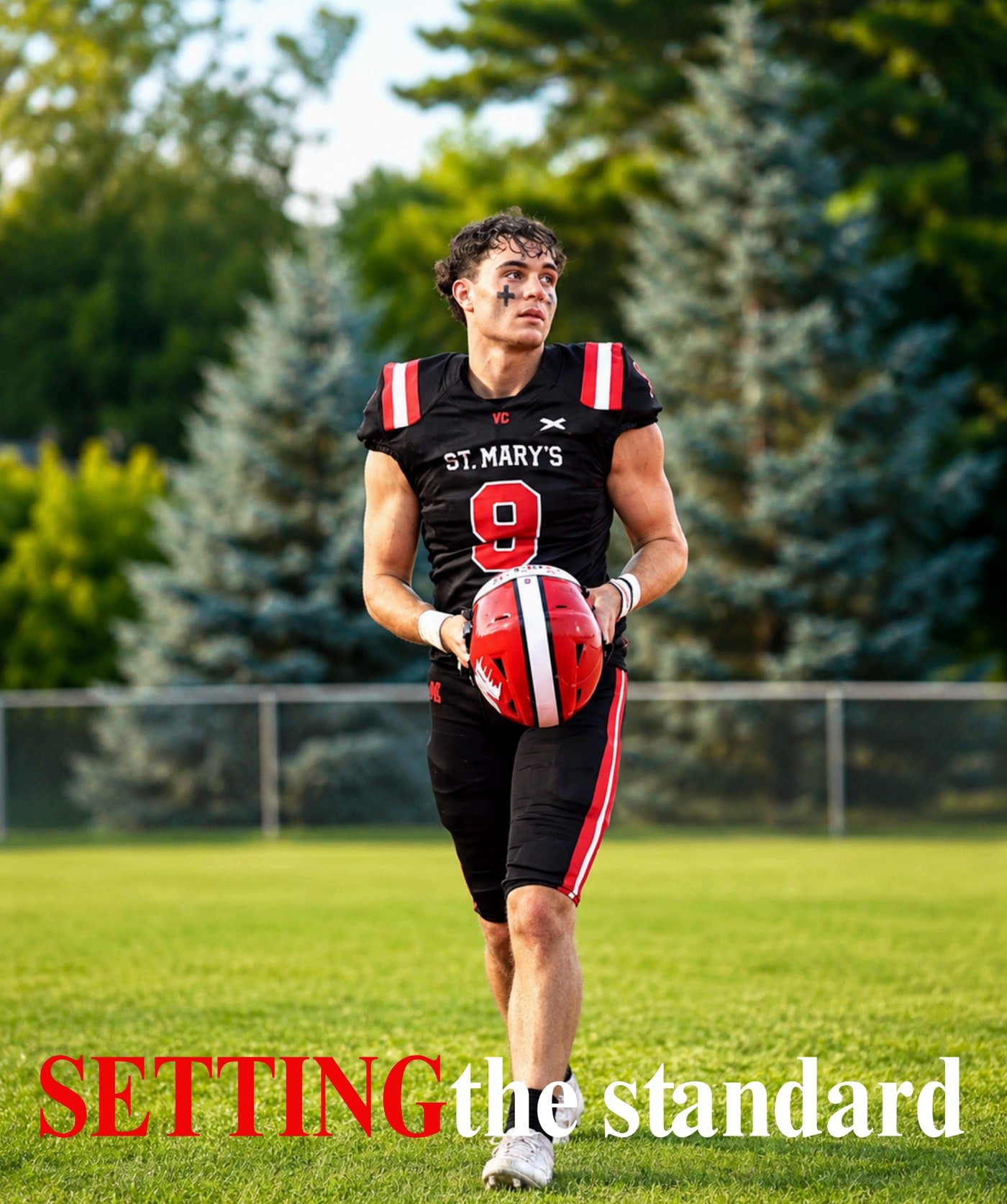 St. Mary’s football player in a black number 9 uniform holding a red helmet
