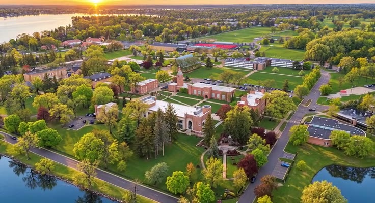 An aerial view of the St. Mary’s campus, surrounding roads, and Orchard Lake at sunset